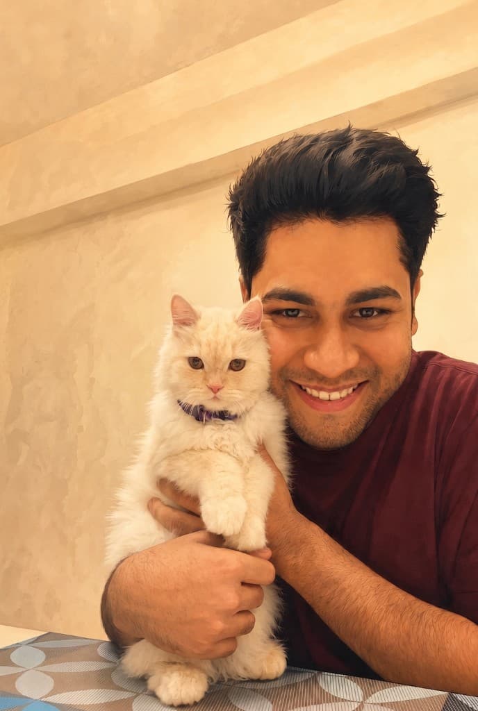 Ginger, a Persian doll face cat, sitting with Yogendra
